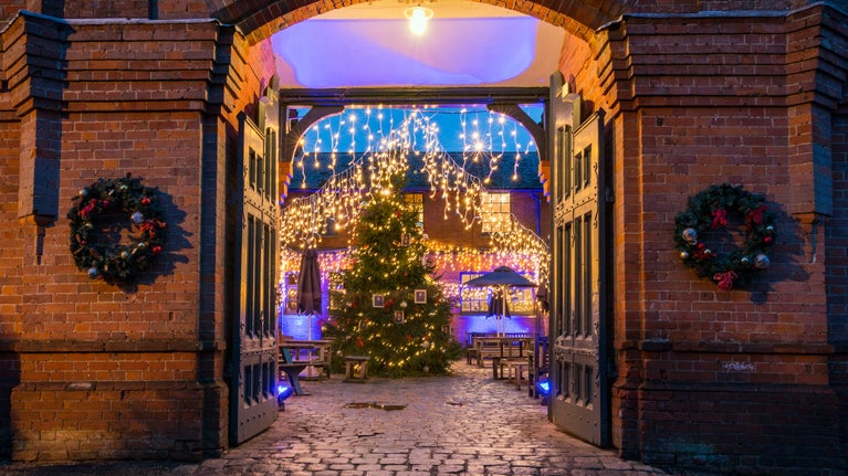 The stableyard decorated with fairy lights, Christmas tree and wreaths at Hughenden.
